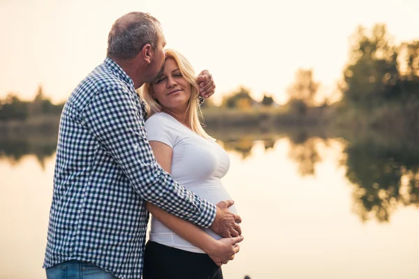 Abrazando el vientre embarazada — Foto de Stock
