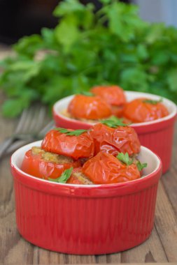 Vejetaryen yiyecekler: Akdeniz usulü fırında makarna, nohut ve ahşap arka planda kırmızı tavada otlarla doldurulmuş domates