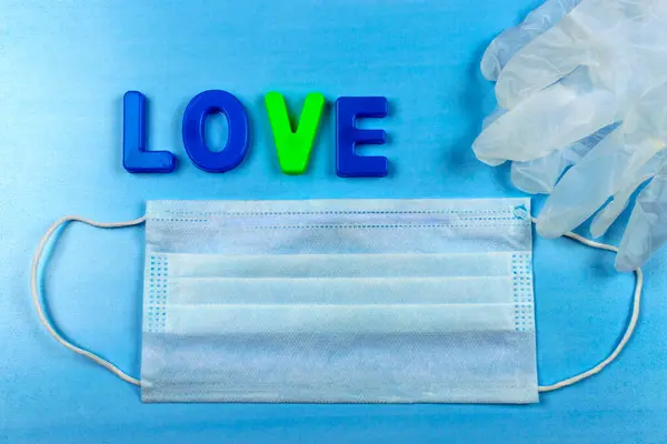 Aşk kelimesi harflerden oluşur. Koronavirüs, tıbbi maske ve eldivenlerden korunma. Halka açık bir yerde korunma aracı..