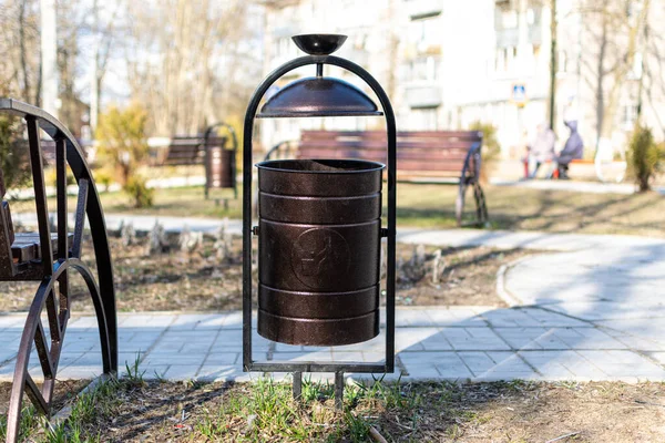 Vazo bankın yanındaydı. Güneşli bir yaz gününün arka planında bir bank olan bir vazo.