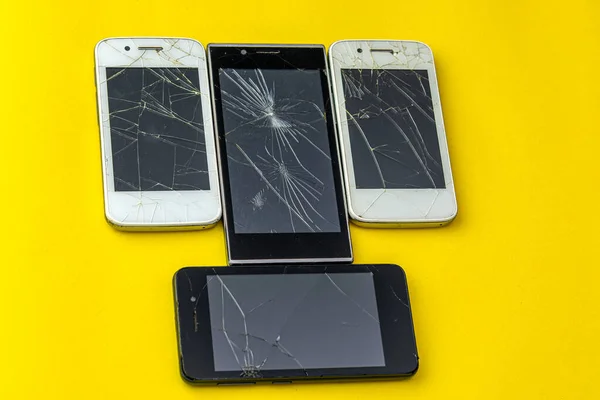 Broken old smartphones. A lot of broken phone displays.
