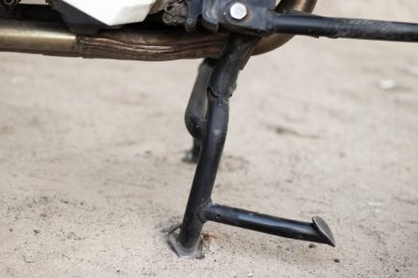 Motorsiklet ayaklığı yerde duruyor. Yan görünümü kapat.