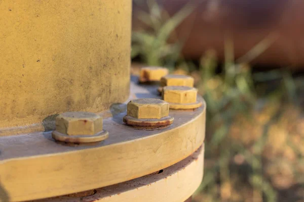 Boruyu sıkıştıran büyük metal cıvatalar. Yakın plan..