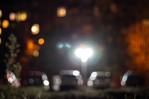 Çok katlı bir binanın akşam ışıkları ve sokak lambaları. Soyutlama.