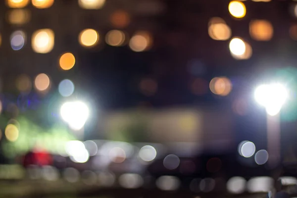 Çok katlı bir binanın akşam ışıkları ve sokak lambaları. Soyutlama.