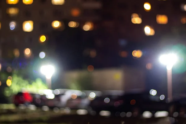 Çok katlı bir binanın akşam ışıkları ve sokak lambaları. Soyutlama.