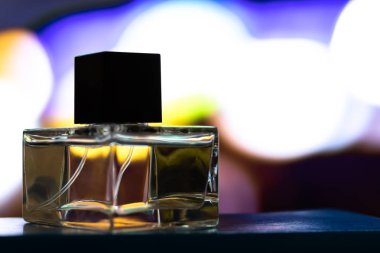 İçi sıvı dolu berrak bardaktan yapılmış parfüm şişesi. Bulanık arkaplanda yakın plan görüntüsü.