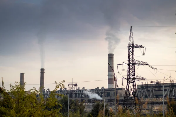 Kalın dumanlı bacaları olan termik santral..