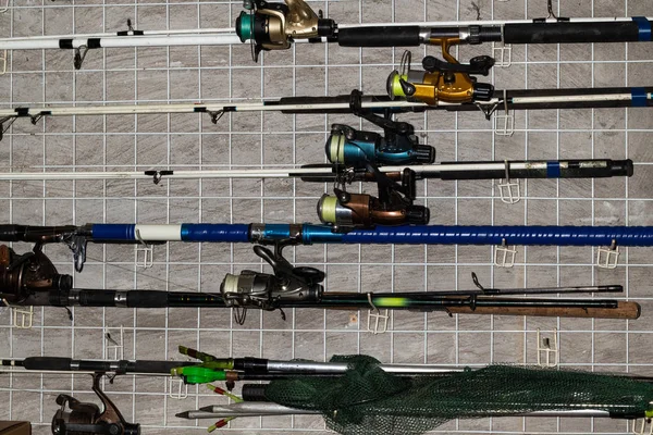 Olta oltaları ve garajdaki duvarda asılı çeşitli balıkçı tekneleri. Yakın plan..