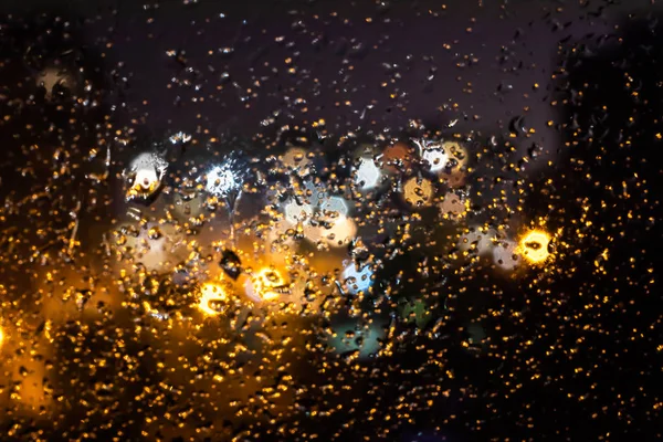 Вечерние Огни Фонарей Домов Городе Через Стекло Покрытое Каплями Дождя — стоковое фото