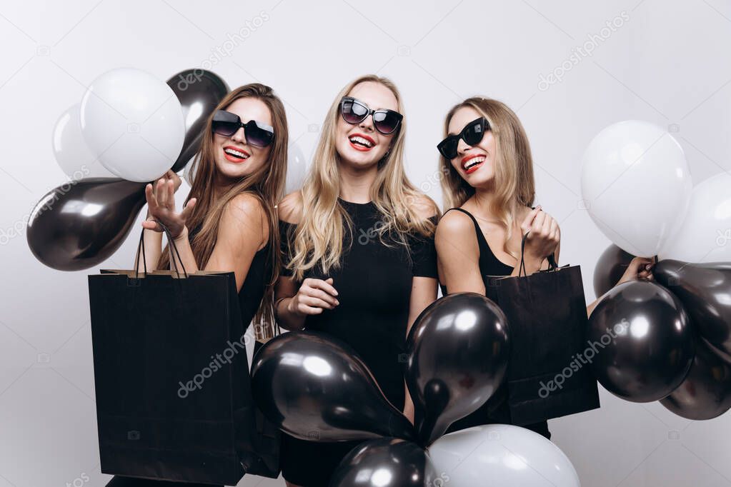 Beautiful Shopping Girls Posing With Black and White Balloons