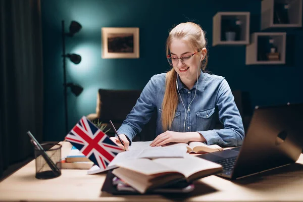 Glada flicka skriver under daglig engelsklektion hemma — Stockfoto