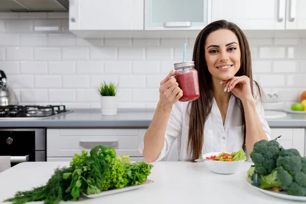 Güzel bir esmer kadın Meyve Smoothie 'sini gösteriyor