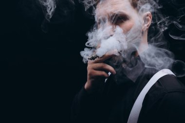 Sakallı Adam 'ın puro içişi, Yüzü dumanla kaplı.