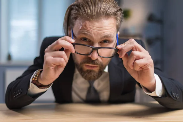 Homme d'affaires barbu Réglage des lunettes et soigneusement les regarder — Photo