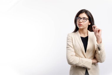 Gözlüklü düşünceli bayan ofis çalışanı yukarı bakıyor.