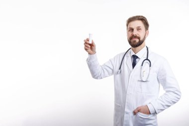 Smiling Physician With Stethoscope Demonstrating a Plastic Bottle of Medication
