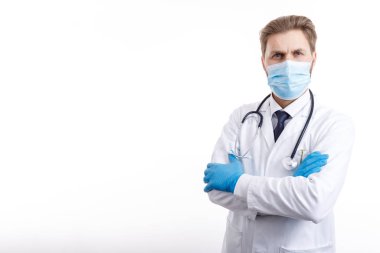 Brown-haired Physician in Mask Posing With Arms Crossed