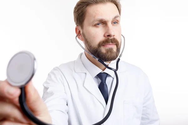Внимательный бородатый доктор в белой аускультации — стоковое фото