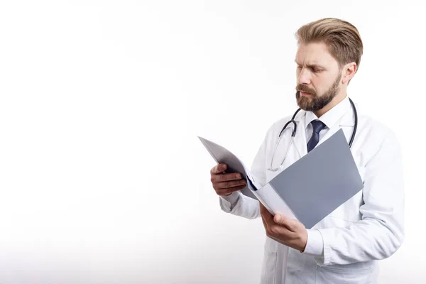 Médico atento en exfoliantes blancos que examina la documentación médica — Foto de Stock