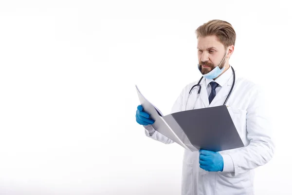 Bearded Doctor in White Scrubs Exploring Medical Documentation — 图库照片