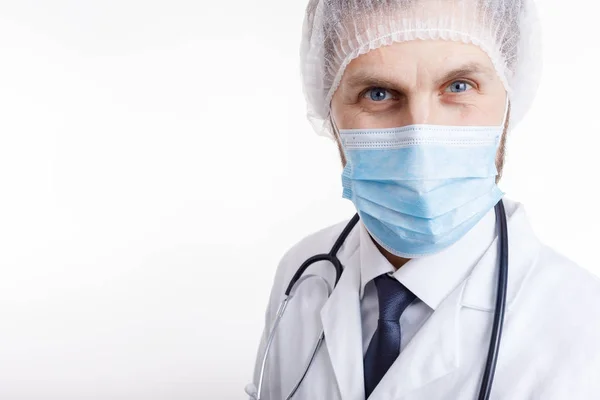 Primer plano del médico masculino en bata blanca, máscara y gorra médica — Foto de Stock
