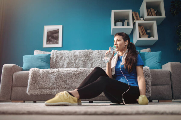 Cheerful Brunette on a Living Room Rug After Physical Training