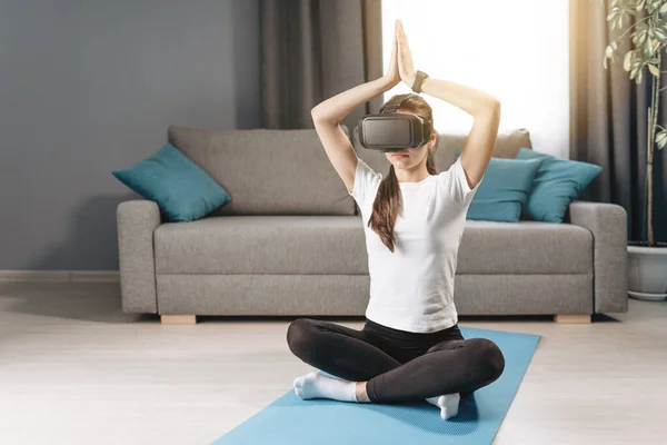 Donna atletica seduta a Padmasana con auricolare VR — Foto Stock