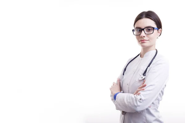 Joven doctora sonriente en exfoliaciones con estetoscopio posando — Foto de Stock