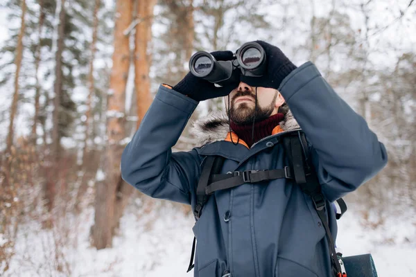 Baard man met behulp van een verrekijker tijdens Winter Forest Trip — Stockfoto
