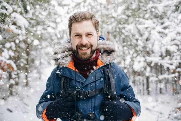 Vrolijk toerist glimlachen in de winter met sneeuw bekleed bos — Stockfoto