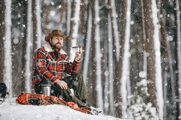 Man toerist rustend op een gezellige Plaid in Winter Forest — Stockfoto