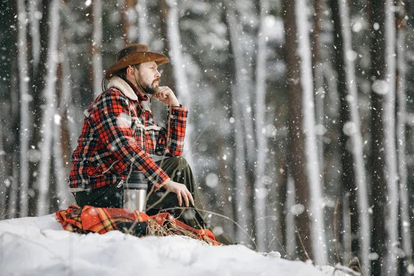 Wandelaar in Checkered Jacket Zittend op een kleine Snowy Forest Hill — Stockfoto