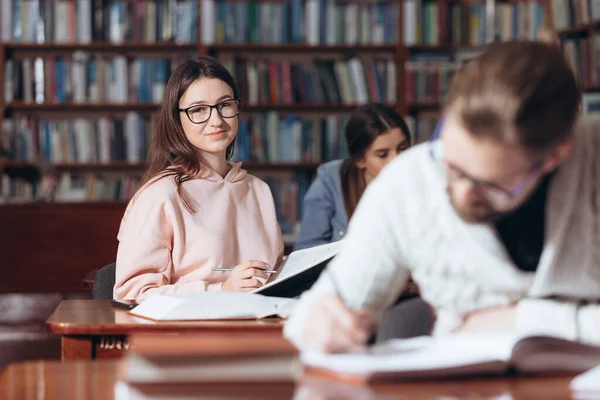 Eine brünette Studentin verbringt Zeit in der Bibliothek — Stockfoto