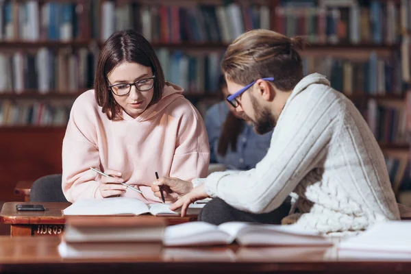 Gammal man hjälper studenten att förbereda sig för tentor på biblioteket — Stockfoto