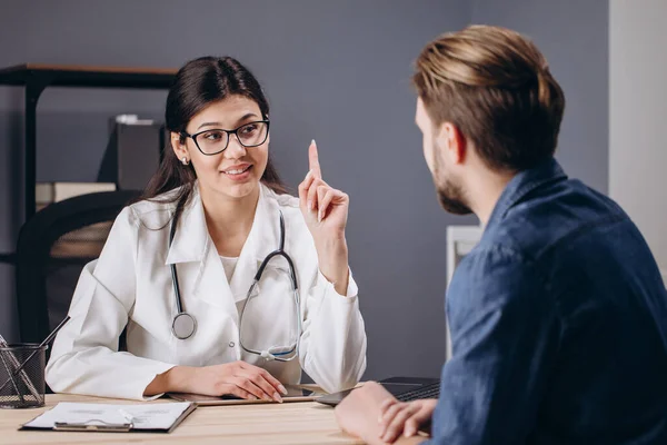 Bonito inteligente jovem médico feminino explicando plano de tratamento — Fotografia de Stock