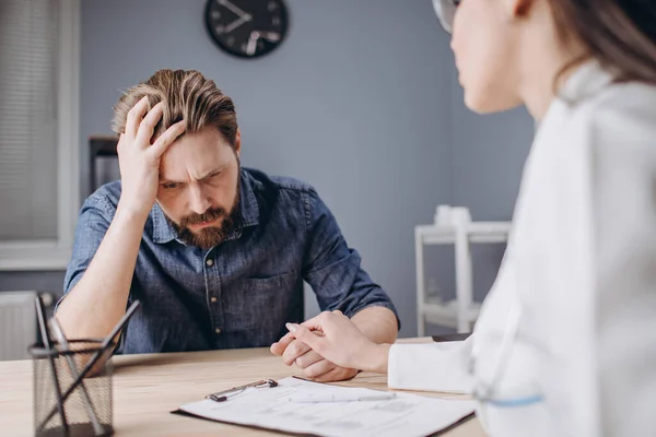 Medico femminile attento confortante paziente barbuto sconvolto — Foto Stock