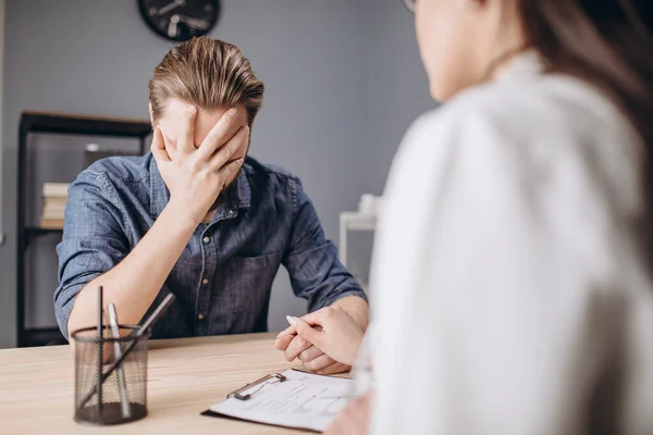 Jong vrouwelijk psycholoog troosten haar man patiënt — Stockfoto