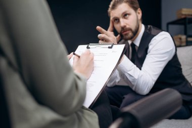 Psikolog seansında resmi giyinmiş olgun bir adam.