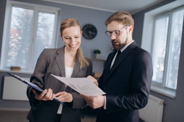 Ofiste elinde belgelerle duran iş ortakları