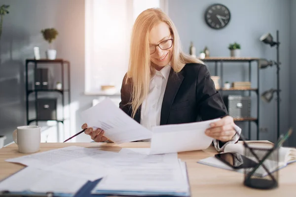 Mature lady doing paper work at modern office — Stock Photo, Image