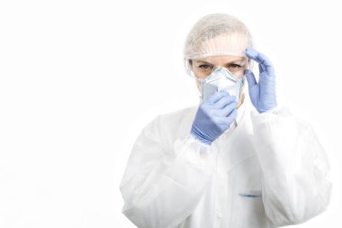 Kameraya poz veren koruyucu kıyafetli kadın doktor.