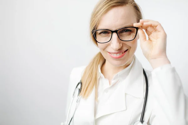 ผู้หญิงในชุดแพทย์และแว่นตา มองไปที่กล้อง — ภาพถ่ายสต็อก