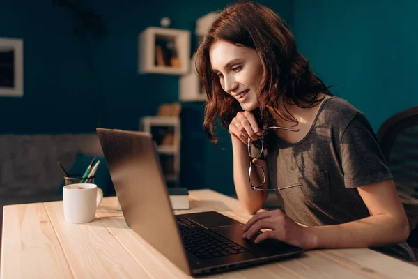 Akşamları laptopta çalışan neşeli bir kadın. — Stok fotoğraf