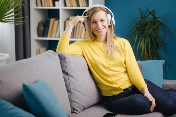 Mujer alegre escuchando música en auriculares inalámbricos — Foto de Stock