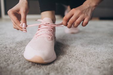 Bağcıklarını bağlayan kızın spor ayakkabılarını kapat.
