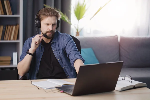 Hombre barbudo en auriculares con videoconferencia en casa — Foto de Stock