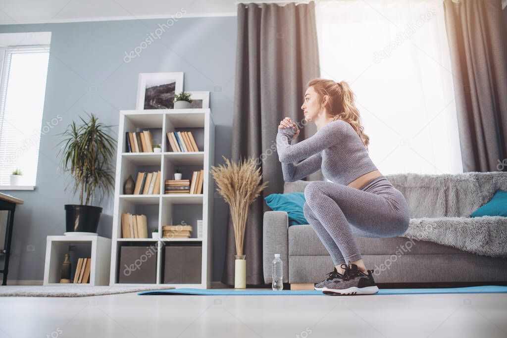 Young girl making sits-up exercises at home