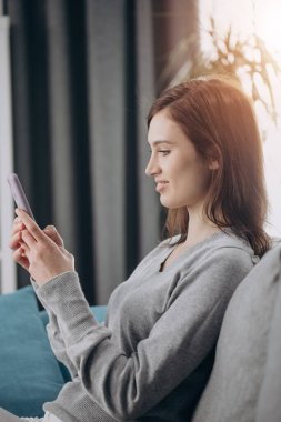 Boş zamanlarında akıllı telefon kullanan mutlu çekici kız.