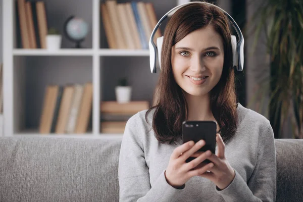 Portrait of girl in wireless headphones relaxing on couch — Stock Photo, Image